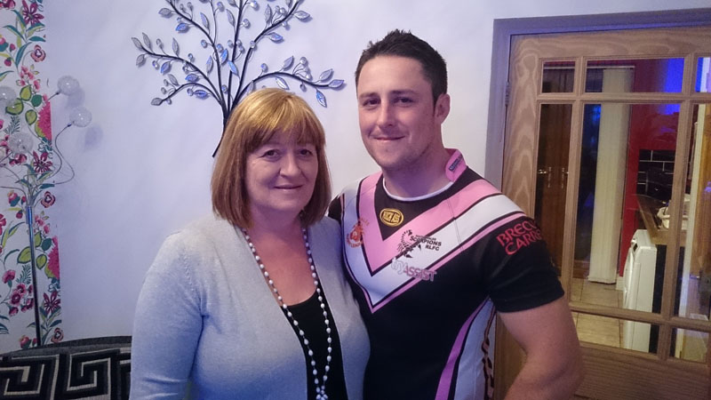 Scorpion player Paul Emanuelli with his mother Kay, wearing a shirt embroidered with the Mothers’ Union logo