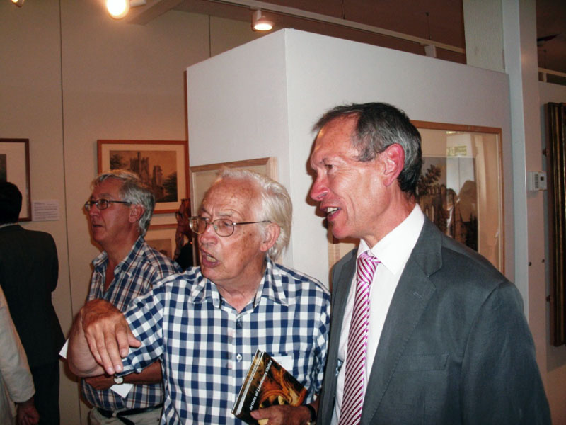 Co-curator William Gibbs discusses the paintings with Culture Minister John Griffiths AM