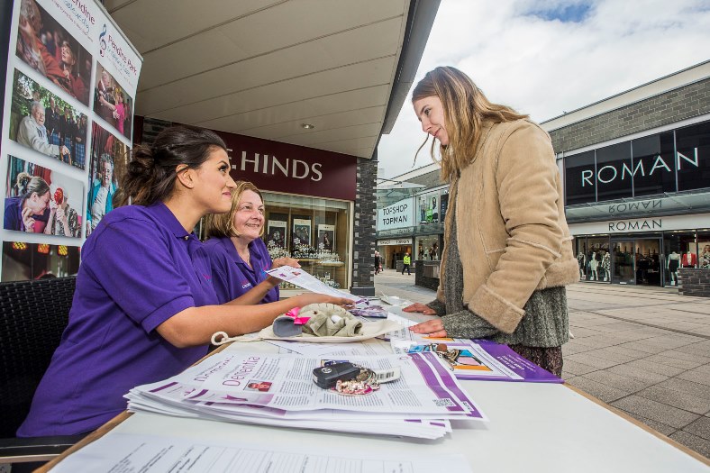 Anita Moran and Olivia Thomas from Pendine Park at an information table in Eagles Meadow, Wrexham giving out information on Dementia Awareness Week talk to Melys Edwards, from Minera