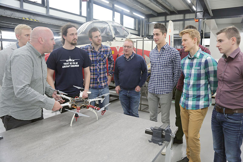 Lecturer Nathan Roberts discusses drone technology with Rob Bolam (back, fourth from left) and current engineering students