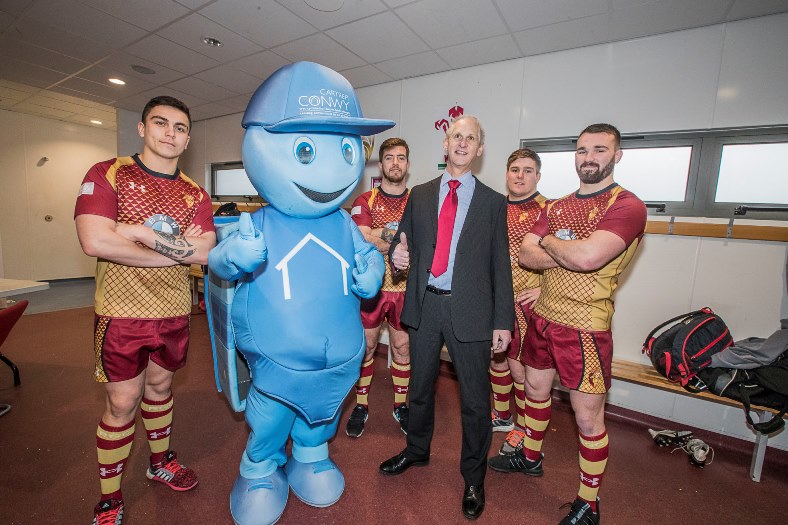Andrew Bowden, chief executive of Cartrefi Conwy with RGC players to promote the fact Cartrefi is sponsoring the rugby club again. From left, Jacob Botica, Tiaan Loots, Evan Yardley and Afon Bagshaw with Cartrefi Conwy mascot Ty Hapi