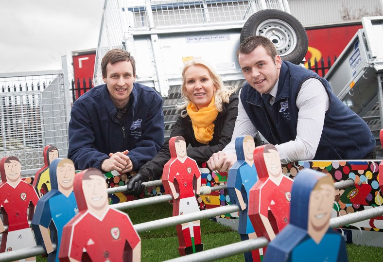 Ifor Williams Trailers have raised £5,000 for Wales Air Ambulance with a football table created from one of their flat bed trailers which was a huge attraction at the Flintshire Eisteddfod. Pictured: Lynne Garlick Fundraising Manager for Wales Air Ambulance along with Ifor Williams Trailers'  Dafydd Gwynedd and Arwyn Evans