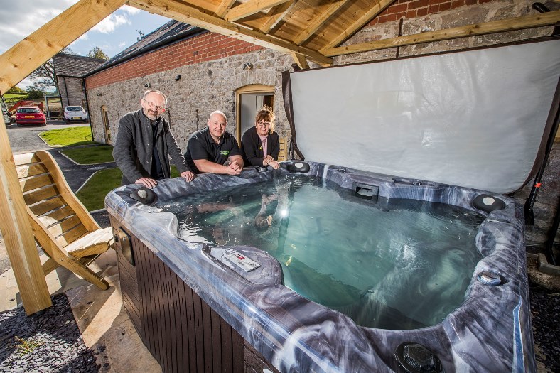 Hot tubs are boosting the income of holiday cottages and pictured at Y Beudy near Pwllglas are David Vasmer, left with Gareth Jones, from UK Leisure Living, and Deborah Nettleton, from North Wales Tourism