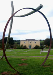 Principality House framed by the metal circle of 'Pi', a sculpture by Rawleigh Clay.