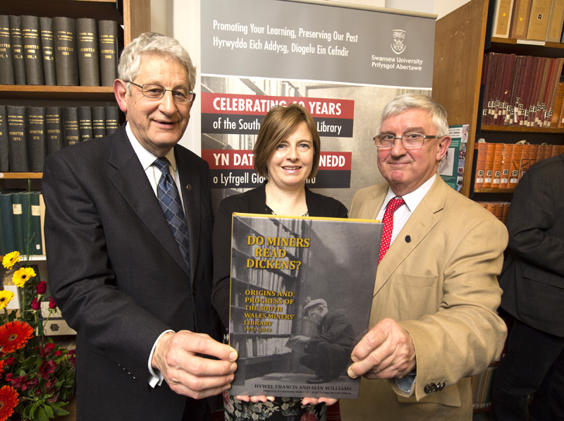 Vice-Chancellor of Swansea University, Professor Richard Davies (left), being presented with a signed copy of Do Miners Read Dickens? a book celebrating 40 years of the South Wales Miners’ Library, by its authors Aberavon MP Dr Hywel Francis and South Wales Miners’ Library librarian Sian Williams