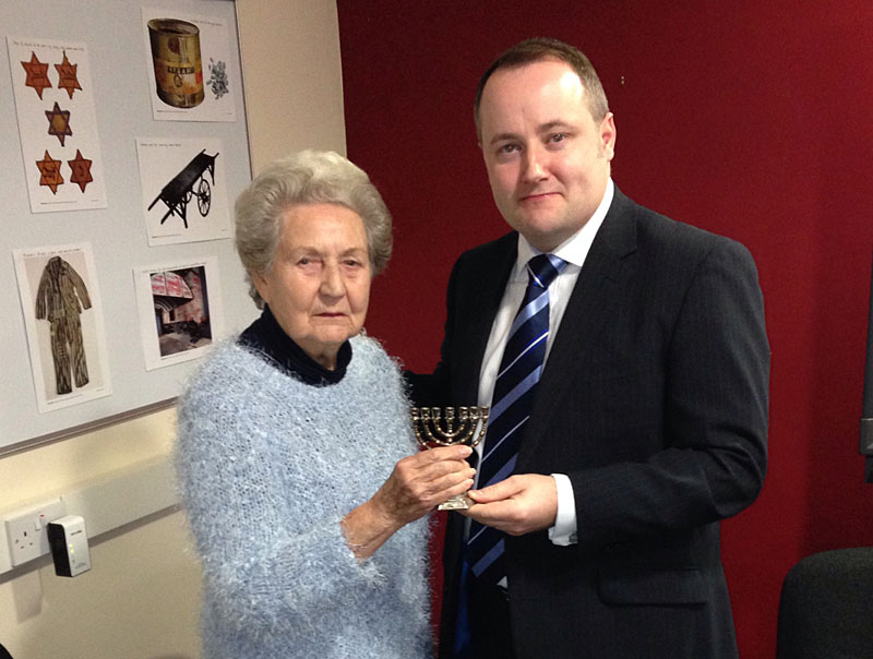 Clwyd West AM Darren Millar is presented with a menorah by Laura Blank, a member of the local Jewish community