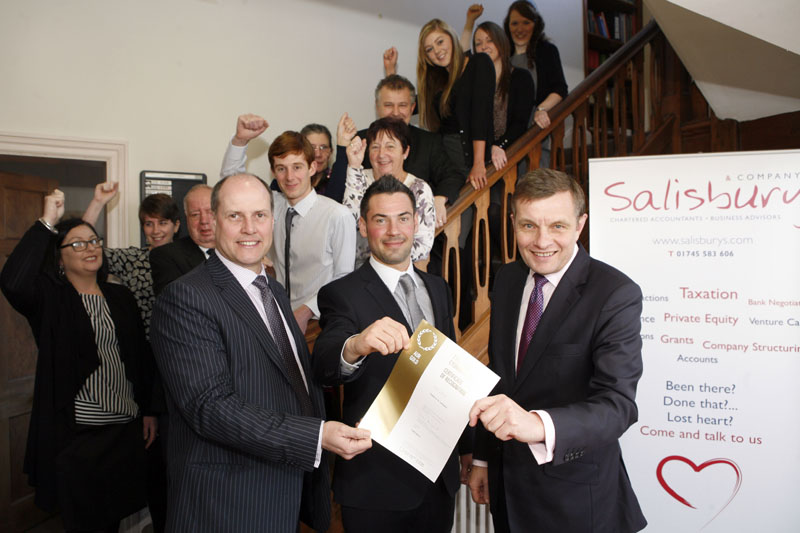 Secretary of State for Wales, David Jones (right) presents the Investors in People Gold award to Jeremy Salisbury (left) and Aled Roberts, directors at Salisbury and Co Accountants, St Asaph, seen here with the successful team