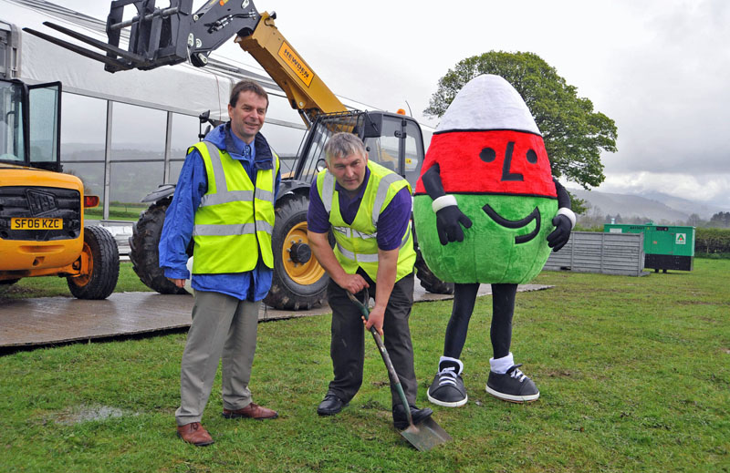 Aled Siôn, Urdd Eisteddfod Director with Hedd Pugh, Executive Chair of Meirionnydd 2014 Urdd Eisteddfod and Mr Urdd cuts the turf at the youth festival held in Bala (25 – 31 May)