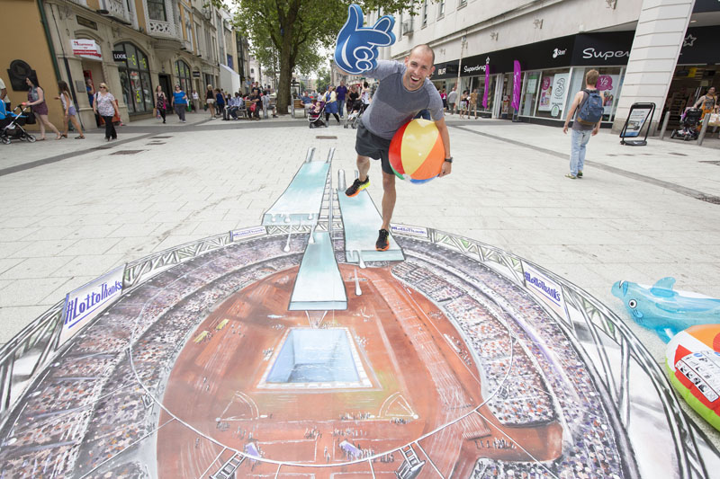 Hurdle champion Dai Greene makes a splash as he poses on a giant 3D art installation in the heart of Cardiff?s city centre to mark 20 years - and over £7billion - of National Lottery funding to sport