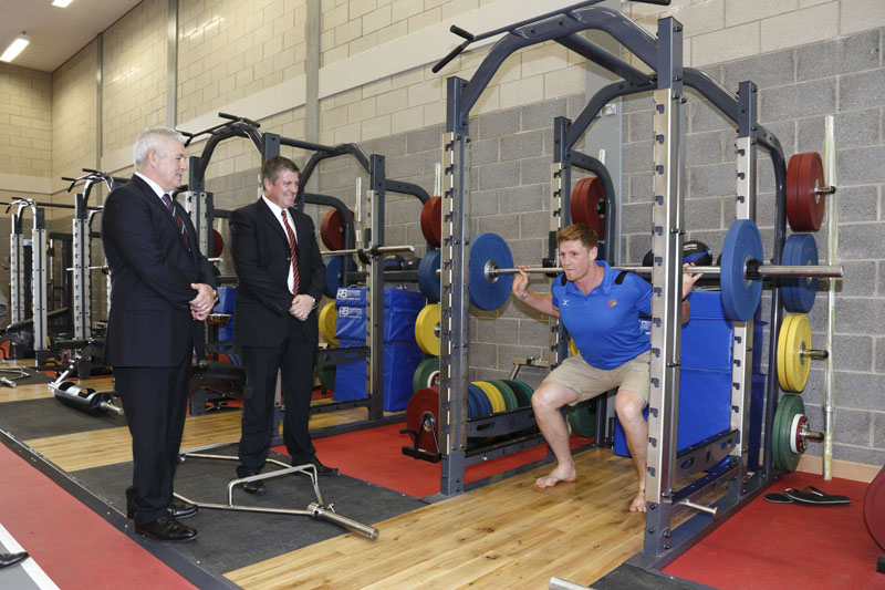 Andrew Coombs at the recent launch of the Caerphilly County Borough Centre for Sporting Excellence, trying out the new gym equipment under the watchful eye of Warren Gatland and Mark Williams, Head of Community and Leisure Services at the council