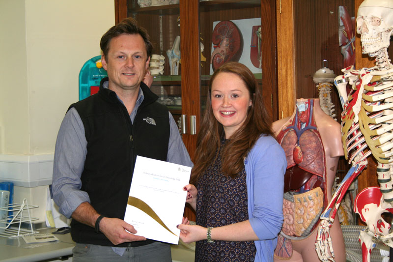 Dr Richard Bracken presenting Stephanie with her Undergraduate Prize certificate in the Swansea University Sports Science Physiology Laboratory