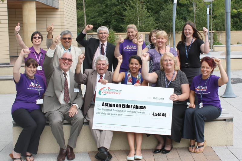 Among those pictured at the cheque presentation are Gabe Conlon of Action on Elder Abuse, Cllr Ken James, Cllr Robin Woodyatt, Cllr Barbara Jones, Corporate Director Social Services Dave Street, Louisa Laurent and members of the POVA team