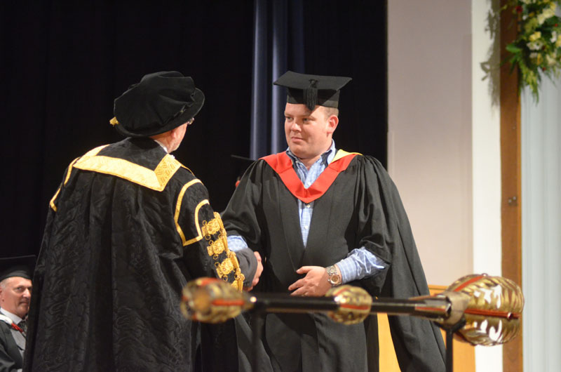  Photo: Sam Shepherd (right) collects his MA Art Practice from Glyndwr University Vice-Chancellor Professor Graham Upton (left)
