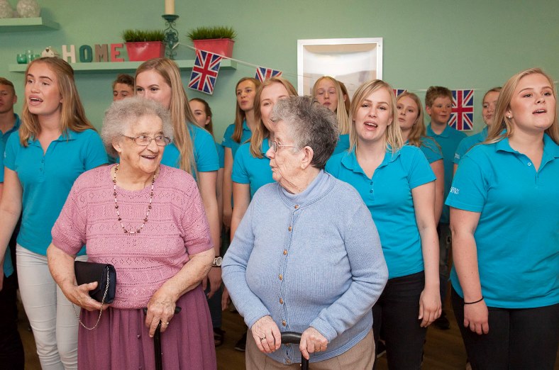 Hilbury Care Home in Wrexham enjoy a flash visit from Awesome Voices Choir from Norway on their way to the Eisteddfod. Pictured: Residents Doreen Cartwright and Betty Coggins join in with the choir
