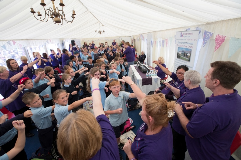 Llangollen International Musical Eisteddfod 2016. Pendine Park staff ad residents with visiting children at a music workshop in their marquee.