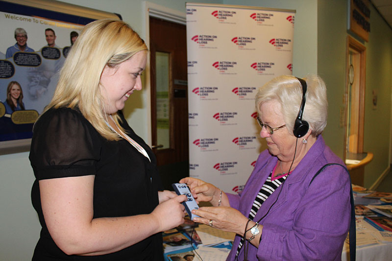 Jeni Bone from Action on Hearing loss with Chris Dyer from Penarth in the University Dental Hospital in Cardiff demonstrating a Sonido personal listening device